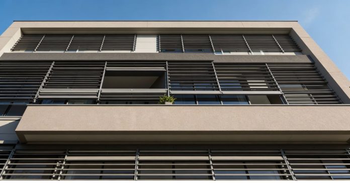 Residential building façade with external metal louvers for smart solar shading reducing heat gain glare and cooling energy use