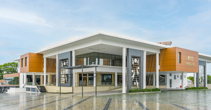 Contemporary public building with white structure, wood accents, large glass walls, and a spacious entrance.